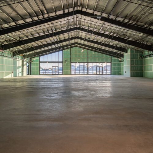 Large retail space interior with exposed metal beams.