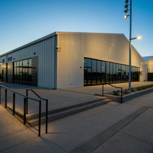 Modern retail center in San Pedro, CA viewed at night featuring a glass wall.